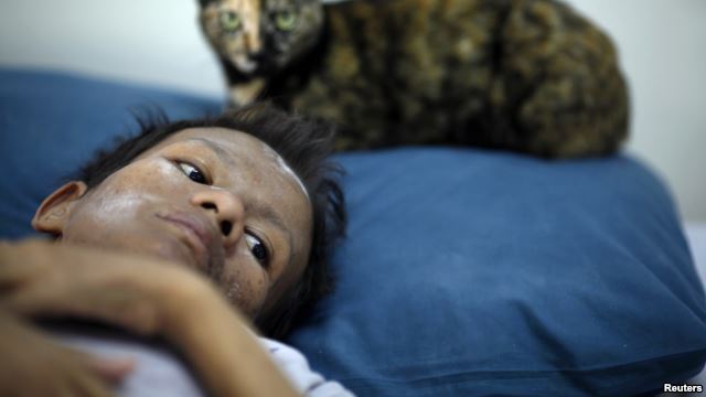 FILE - Samruei, a 35 year-old terminally ill Thai woman rests with her cat at a hospice for those dying of AIDS at a Buddhist temple Wat Prabat Nampu in Lop Buri. FILE - Samruei, a 35 year-old terminally ill Thai woman rests with her cat at a hospice for those dying of AIDS at a Buddhist temple Wat Prabat Nampu in Lop Buri.