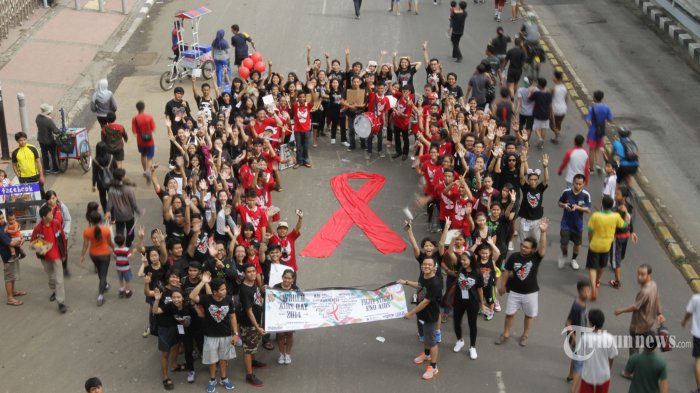 Aktivis yang berasal dari tim peduli aids (TPA) Universitas Atma Jaya membuat tanda pita sebagai simbol peduli terhadap pengidap HIV/AIDS | TRIBUNNEWS/HERUDIN